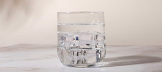 A glass of iced water on a marble surface