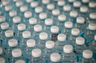 Rows of plastic bottled water with white caps